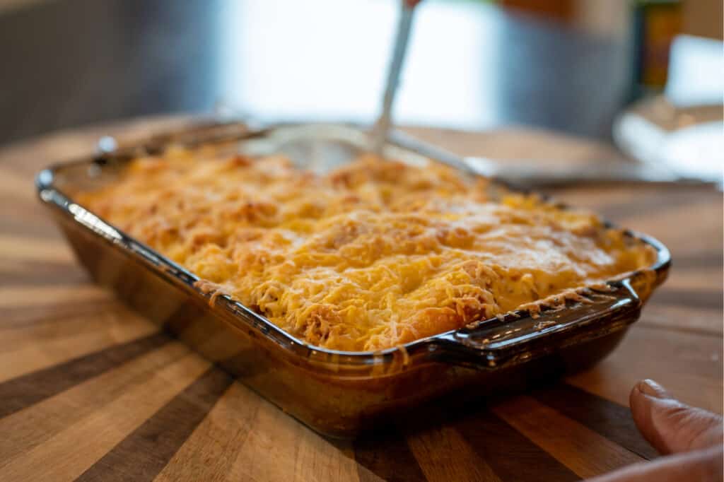 a casserole dish with lasagna on a wooden table